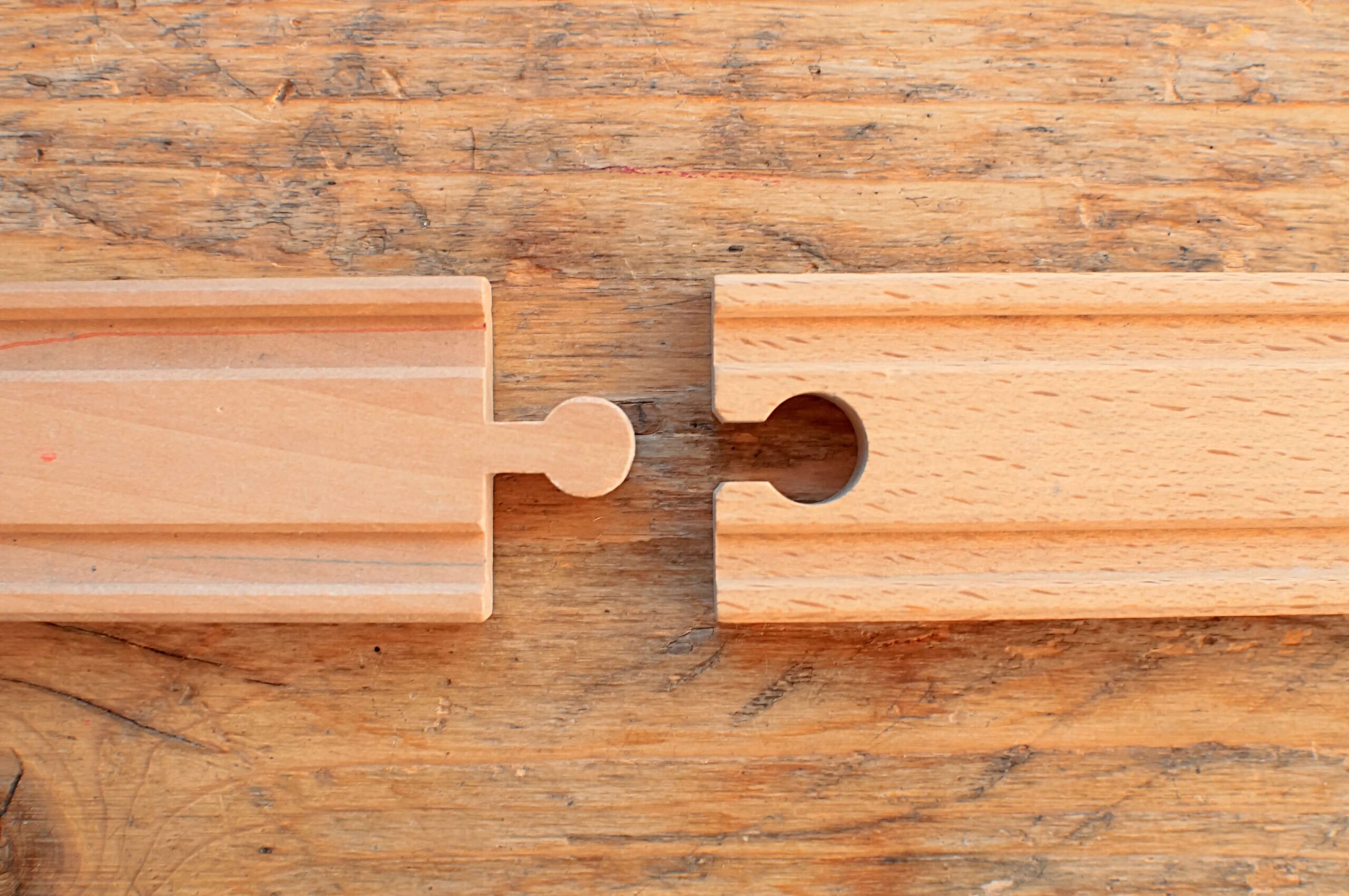 train-track-closing-the-gap-iStock-962316564 closing the gap between two segments of wooden toy train track