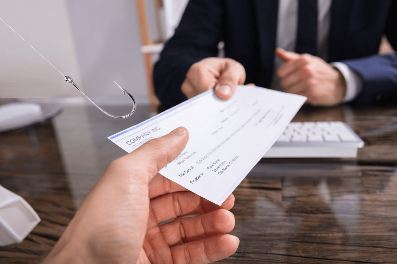 Image of man handing a company check with a fishing hook reaching out