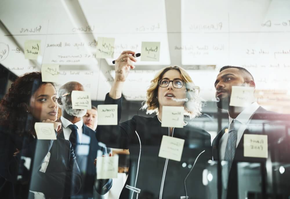 People collaborating on white board